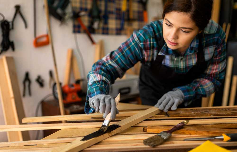 A lady carpenter is making furniture.
